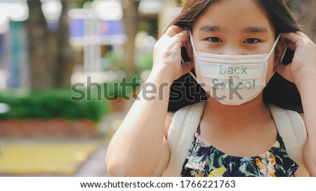 Back to school. asian child girl wearing face mask with backpack  going to school .Covid-19 coronavirus pandemic.New normal lifestyle.Education concept.