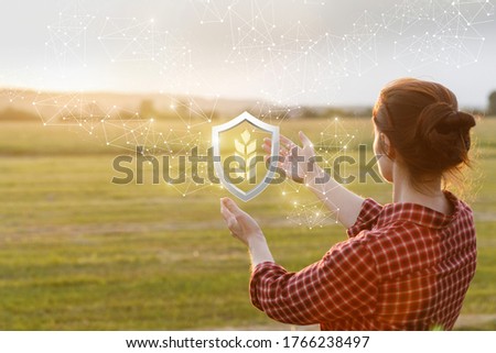 The concept of a quality harvest guarantee.Farmer showing shield with an ear of wheat inside. Royalty-Free Stock Photo #1766238497