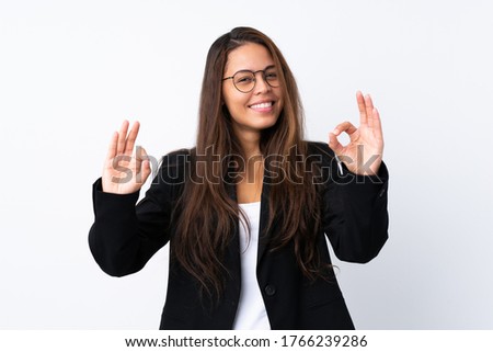 Young Brazilian girl with blazer over isolated white background showing an ok sign with fingers