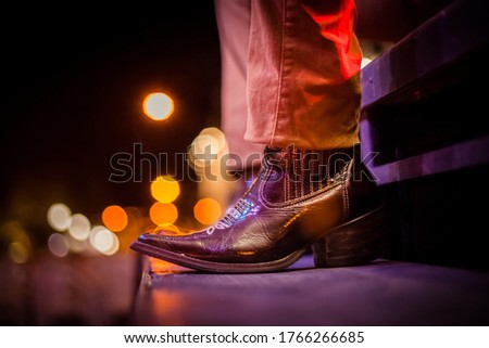 Cowboy leather boot with blurred lights background