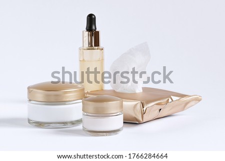 A set for the care of the skin around the eyes and skin consisting of cleaning wipes, glass jars of cream and a bottle with a serum pipette.