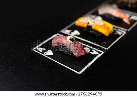 Hand drawn Poker cards with Japanese sushi nigiri on dark chalkboard background. Asian food with tuna tataki, omelette, and black rice. King and Ace of Hearts chalk cards with Maguro and Tomago dishes