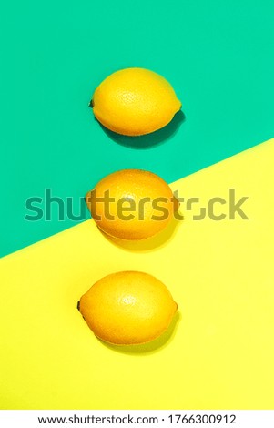 Creative layout made of lemons on bright yellow and trendy green blue background. Fruit minimal concept. Top view, flat lay, close up.