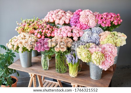 Many different colors on the stand or wooden table in the flower shop. Showcase. Background of mix of flowers. Beautiful flowers for catalog or online store. Floral shop and delivery concept. Top view Royalty-Free Stock Photo #1766321552