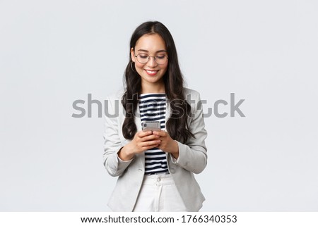 Business, finance and employment, female successful entrepreneurs concept. Businesswoman waiting for client, checking messages in smartphone, wearing glasses as looking at mobile screen