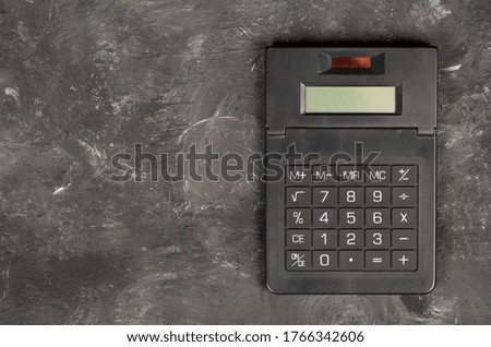 Pocket calculator on dark black background with copy space - tax, finance or accounting concept, top view flat lay from above