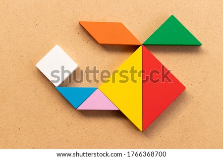 Color tangram puzzle in copter or helicopter shape on wood bacground