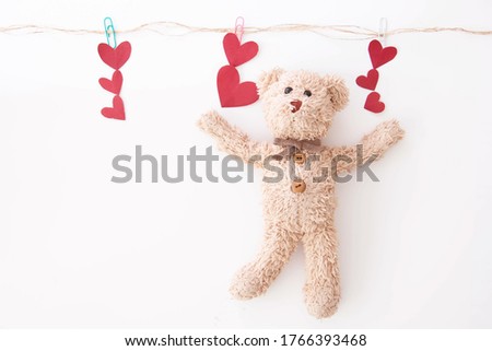 The cute little teddy bear is so happy with many hearts in valentine.