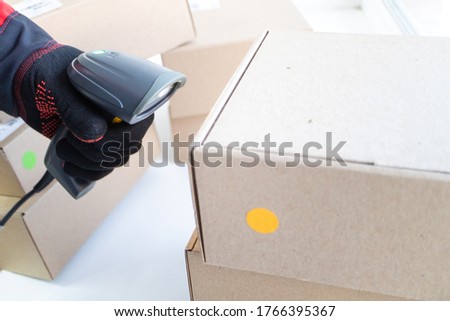 the process of accounting for goods in stock using a barcode reader. worker blows accounting boxes