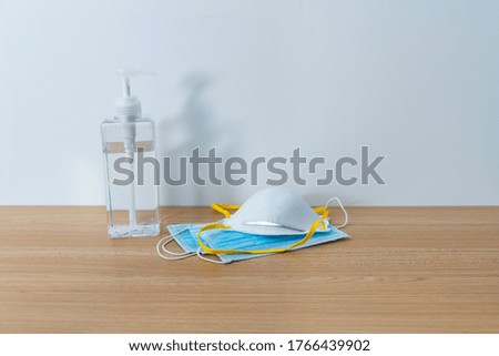 Hand sanitizer and medical masks on the table.