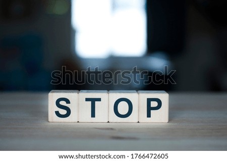 The word stop on a wooden cube. Letter constructor