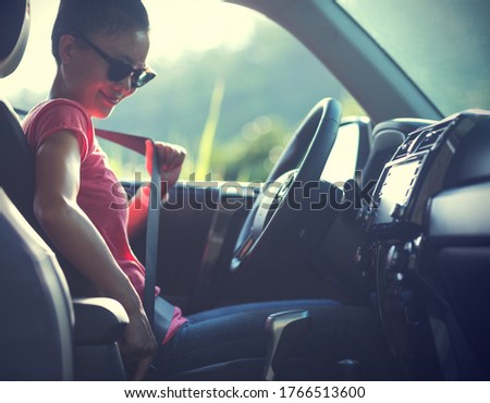 Woman driver buckle up the seat belt before driving car Royalty-Free Stock Photo #1766513600
