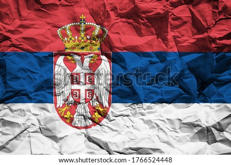 National flag of Serbia on crumpled paper. Flag printed on a sheet. Flag image for design on flyers, advertising.