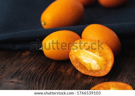 Kumquat citrus fruit on dark wooden table