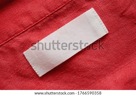 Blank clothing tag label on linen shirt fabric texture background