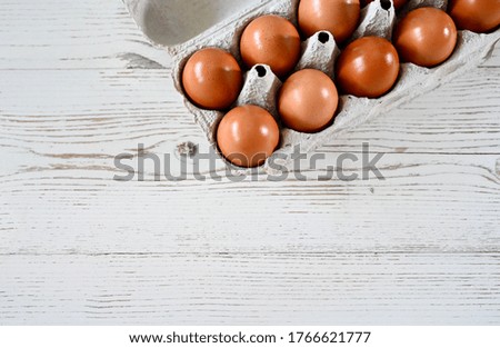 Fresh brown chicken eggs with carton box .