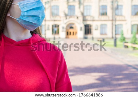 Cropped close up photo portrait of young girl in casual red jumper wearing surgical medicine mask going to hospital