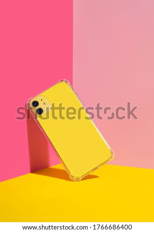 Yellow iPhone in clear phone case, bright and colorful phone case mock up  Royalty-Free Stock Photo #1766686400