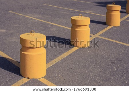 yellow concrete posts in a parking lot