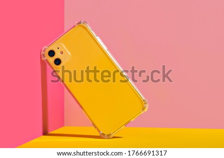 Yellow iPhone 11 in clear phone case, bright and colorful phone case mock up  Royalty-Free Stock Photo #1766691317