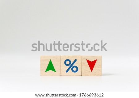 Interest rate financial and mortgage rates concept. Wooden cube block with icon percentage symbol and arrow up and down direction