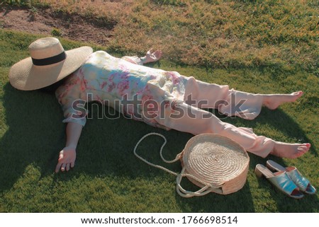 Adult woman lying at garden grass with very style