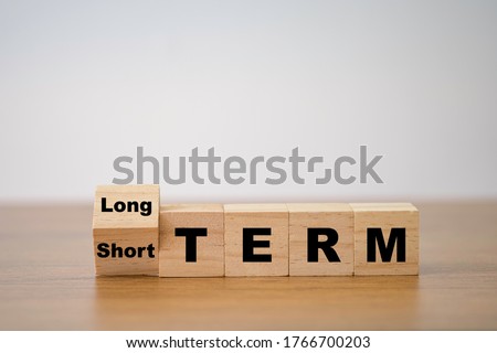 Flipping od wooden cube block for change short term to long term. Business investment concept. Royalty-Free Stock Photo #1766700203