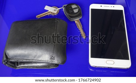 Close up cellphone, car key and wallet