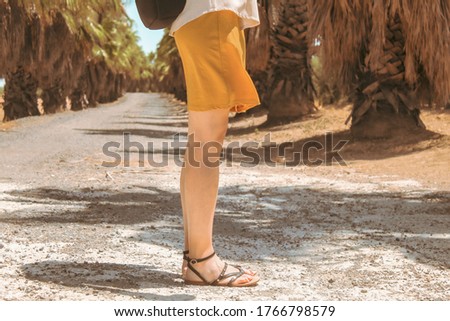 Attractive and young adult woman enjoying summer vacation and nature visiting outdoor spaces due to social distancing