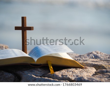 Open bible  and wood holy cross with  blue sea as background. Love study bible , holy book , Christianity concept.