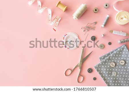 Tailor feminine workplace frame Accessories and tools for sewing on a pink background. Top view