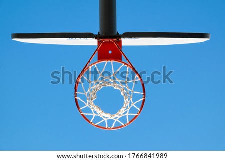 A basketball hoop shot from below with a clear blue sky background