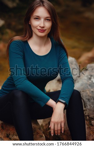 Female tourist in the forest resting near the river. Female hiking by the creek.