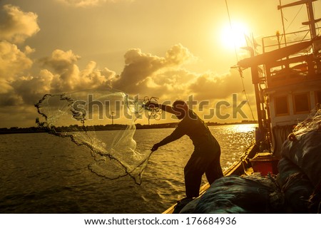 Silhouettes fisherman casting on a crab boat. Royalty-Free Stock Photo #176684936