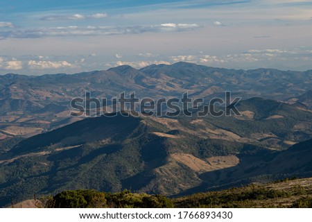 fields and hills of the cerrado under a colorful sky