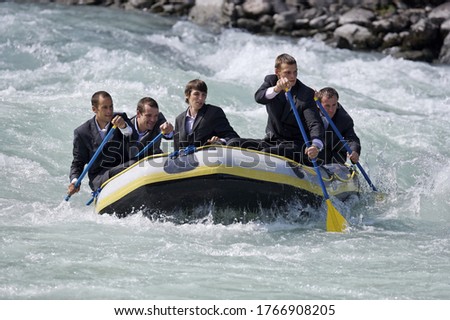 Group of businessmen whitewater rafting