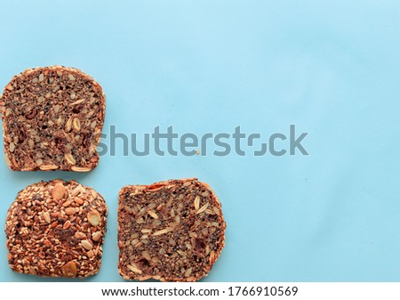 Sliced whole grain bread rye with seeds flax, sunflower, pumpkin and sesame.Healthy food, eco-friendly natural products. Fresh bread on a pink background.