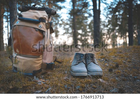 camping in the forest. boots and a backpack stand on the ground against the background of the forest