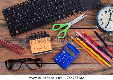 School homework accessories on a wooden table. Knowledge is power. Top view flat lay.