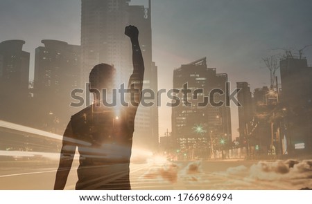Strong, motivated, inspired man in the city with fist up to the sky. Double exposure.  Royalty-Free Stock Photo #1766986994