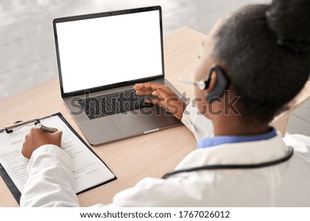 African doctor wear headset consult female black patient make online webcam video call on laptop screen. Telemedicine videoconference remote computer app virtual meeting. Over shoulder videocall view. Royalty-Free Stock Photo #1767026012