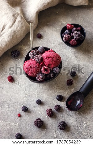 Tasty summer berries yogurt ice cream with berries on grey background
