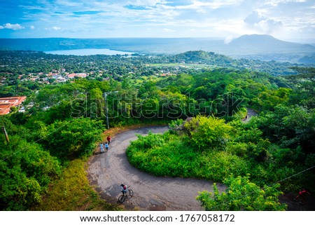 Lagoon, volcano and city landscape, with tourist pedestrian path in the foreground. Panoramic view. Masaya, Nicaragua.