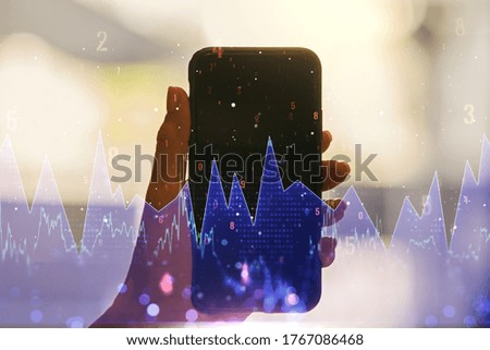 Multi exposure of abstract statistics data hologram interface and hand with cellphone on background, computing and analytics concept