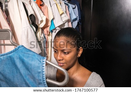 Portrait of a smiling woman choosing a blouse in her dressing room