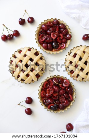 Homemade individual Lattice Cherry pie in the making before bake. Simple, delicious patisserie, home rustic baking, summer french dessert concept. Top view, flat lay, Copy space  