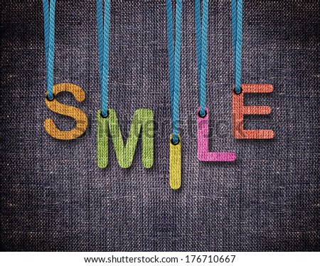 Smile Letters hanging strings with blue sackcloth background.