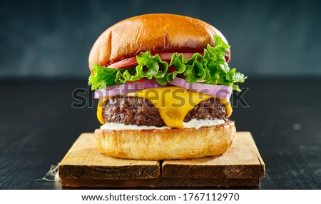 thick cheeseburger with american cheese, lettuce tomato and onion Royalty-Free Stock Photo #1767112970