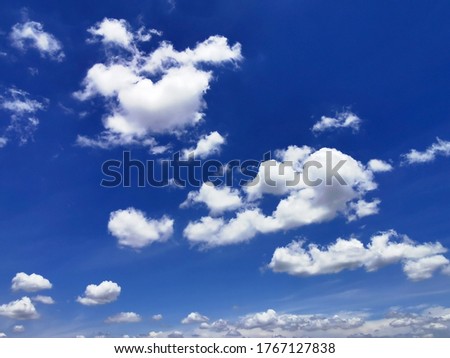 On a bright sunny day in the silver blue sky with white gray clouds floating in the air beautifully. The background is a blue sky Is a picture of clouds in the sky in beautiful nature