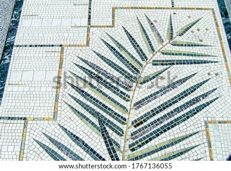 Top view of the texture of the sidewalk with a mosaic facing with a branch pattern, in the open
